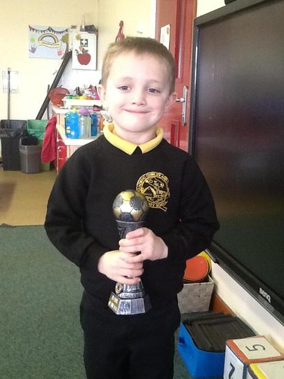 George proudly showing his trophy for playing football. 